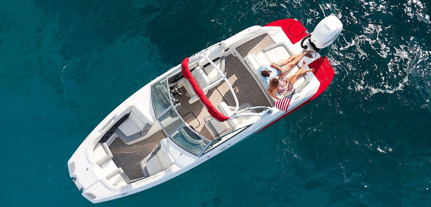 Aerial shot of a couple relaxing on a floating speed boat