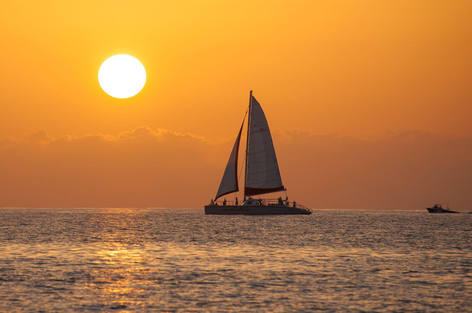 Sailing boat out in the ocean during sunset