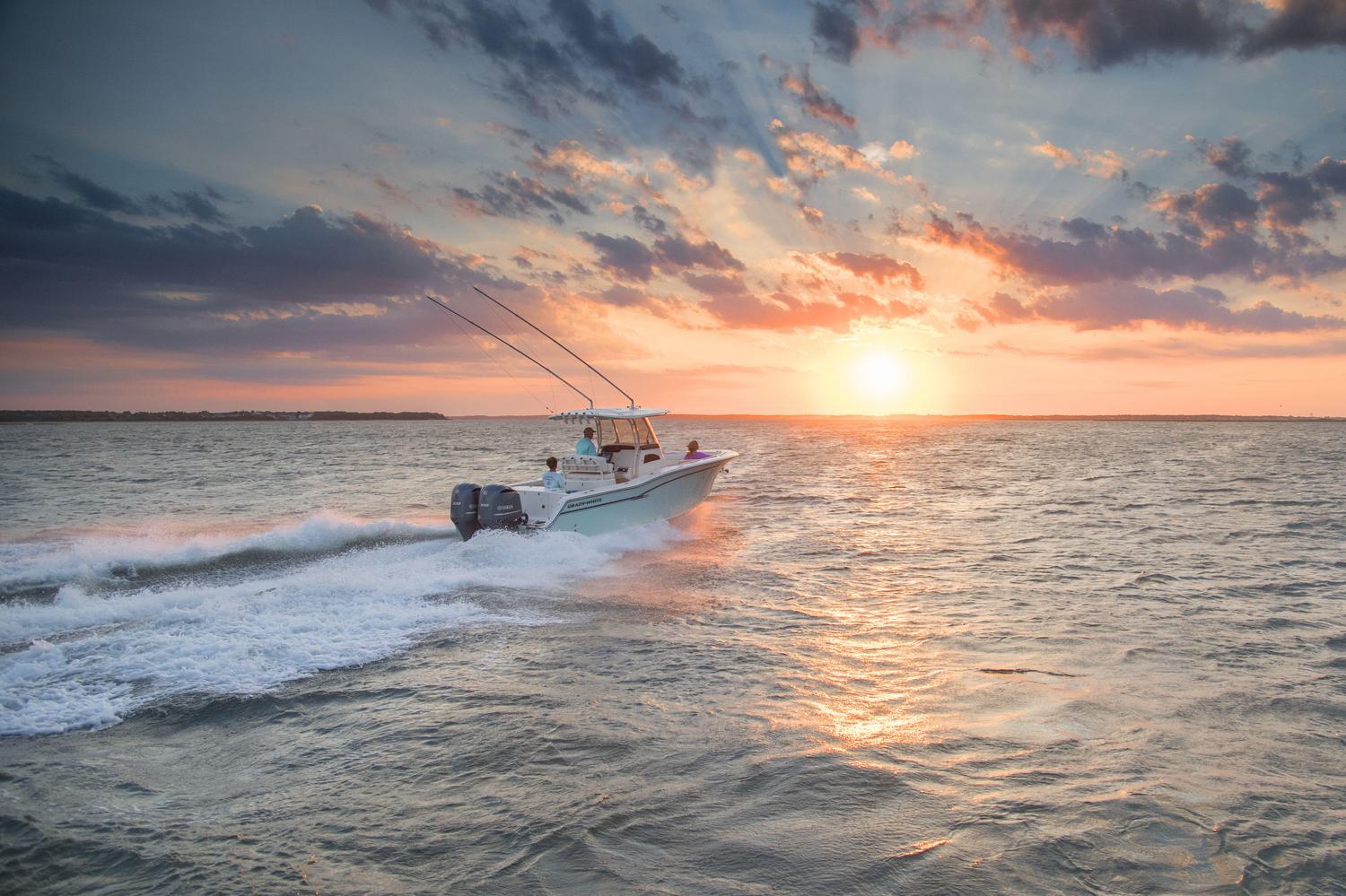 Fishing boat cruising out to sea during sunrise