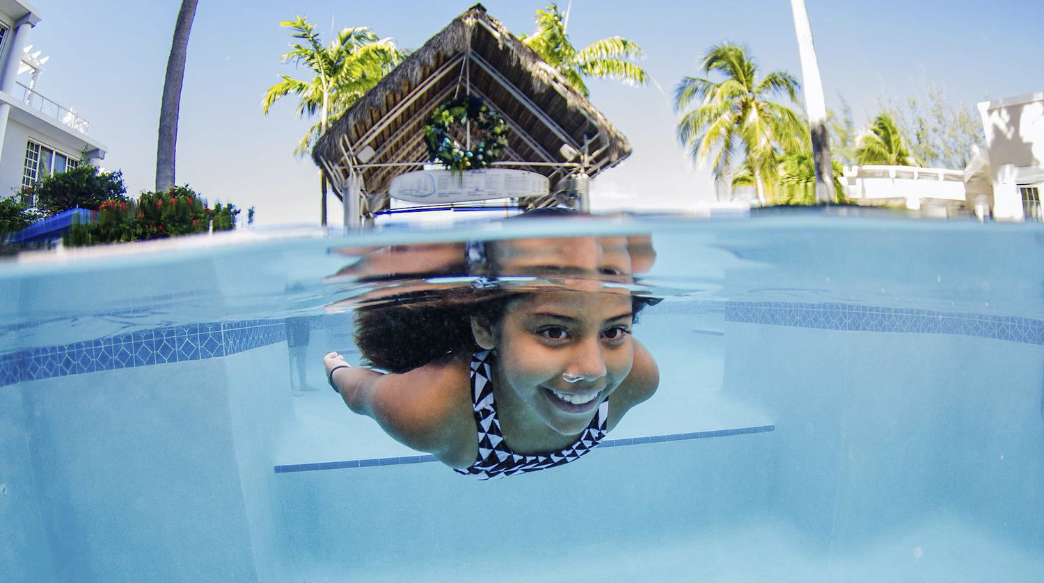 Pool Maintenance Young Girl Swimming Underwater in Pool