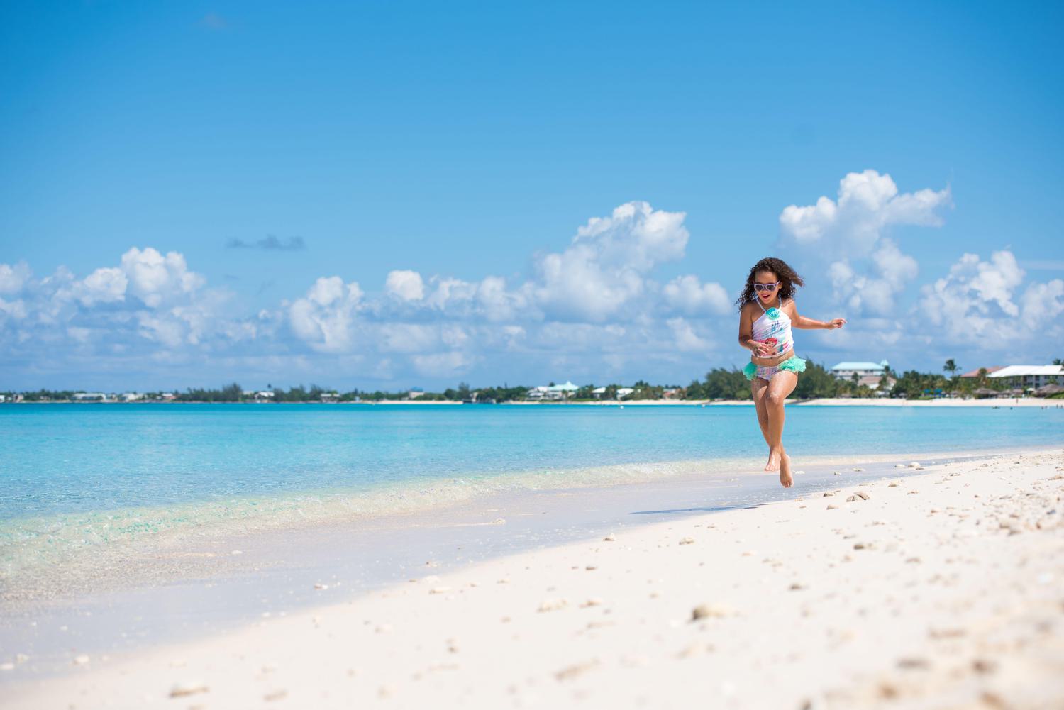 Young girls wearing sunglasses running on the beach