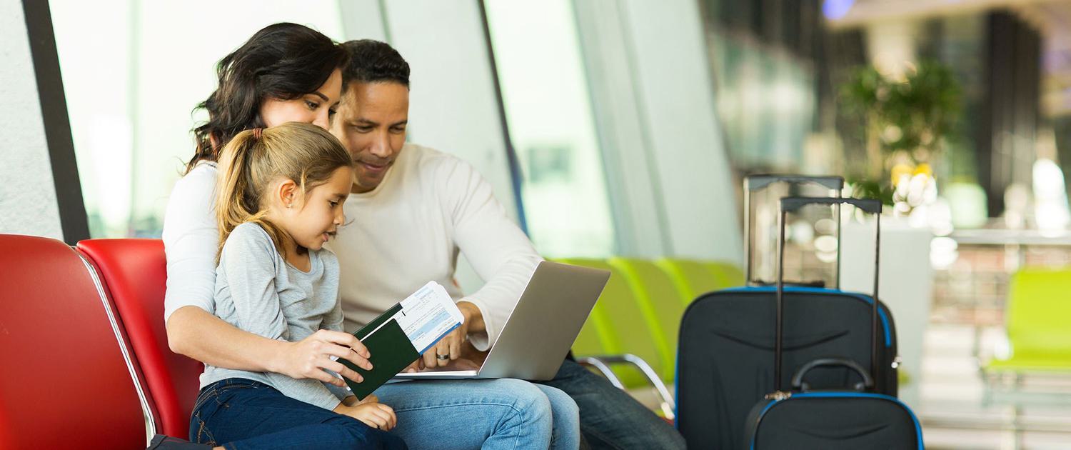 Family sitting in airport with luggage