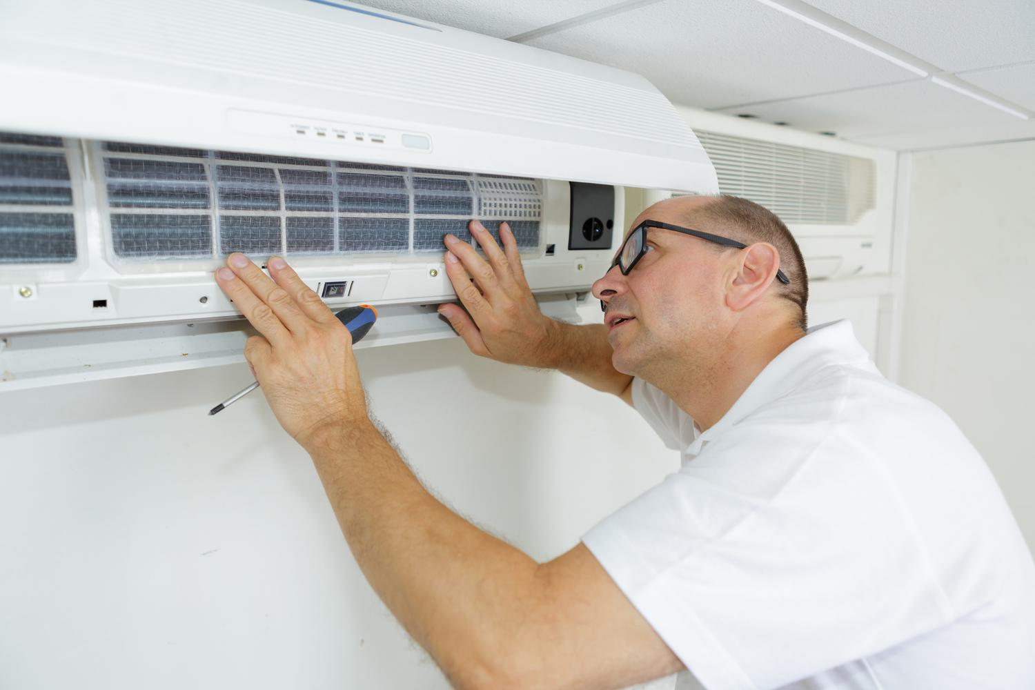 Man in white shirt fixing wall mounted air con