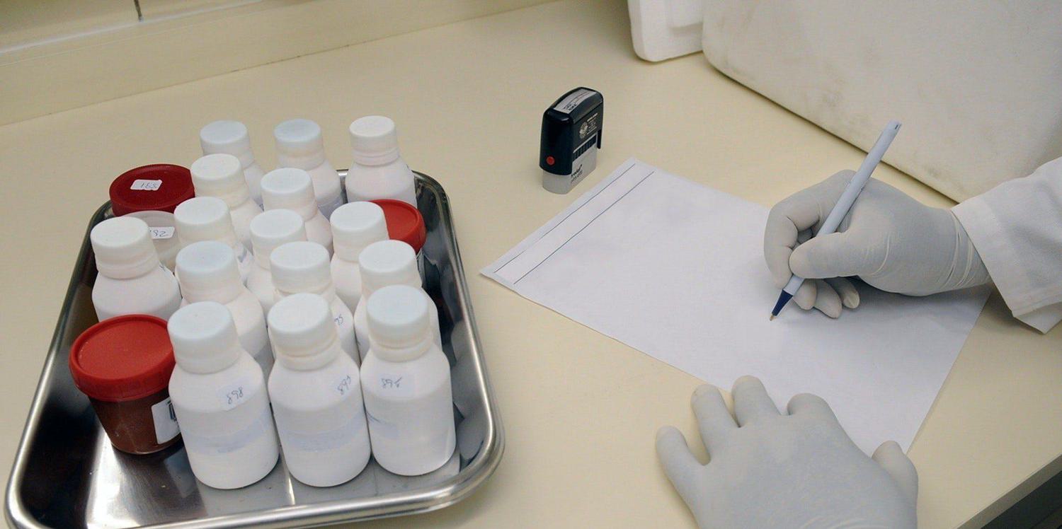 Medical samples on table and person in white hand gloves writing on white paper 207601