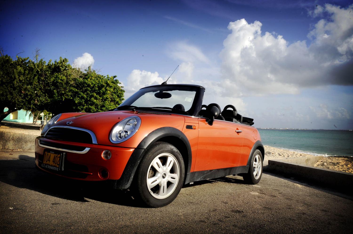 Orange mini cooper parked in front of the water