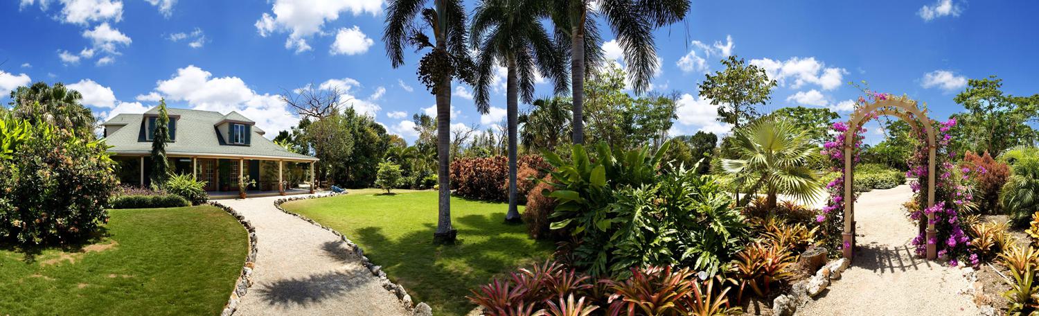 Panoramic view of a beautiful house with front yard garden and arch