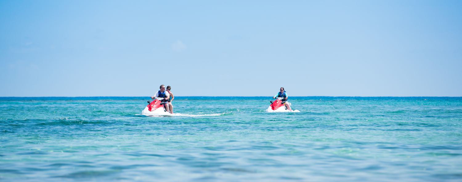 Three people enjoying the afternoon jetskiing on the beautiful blue ocean