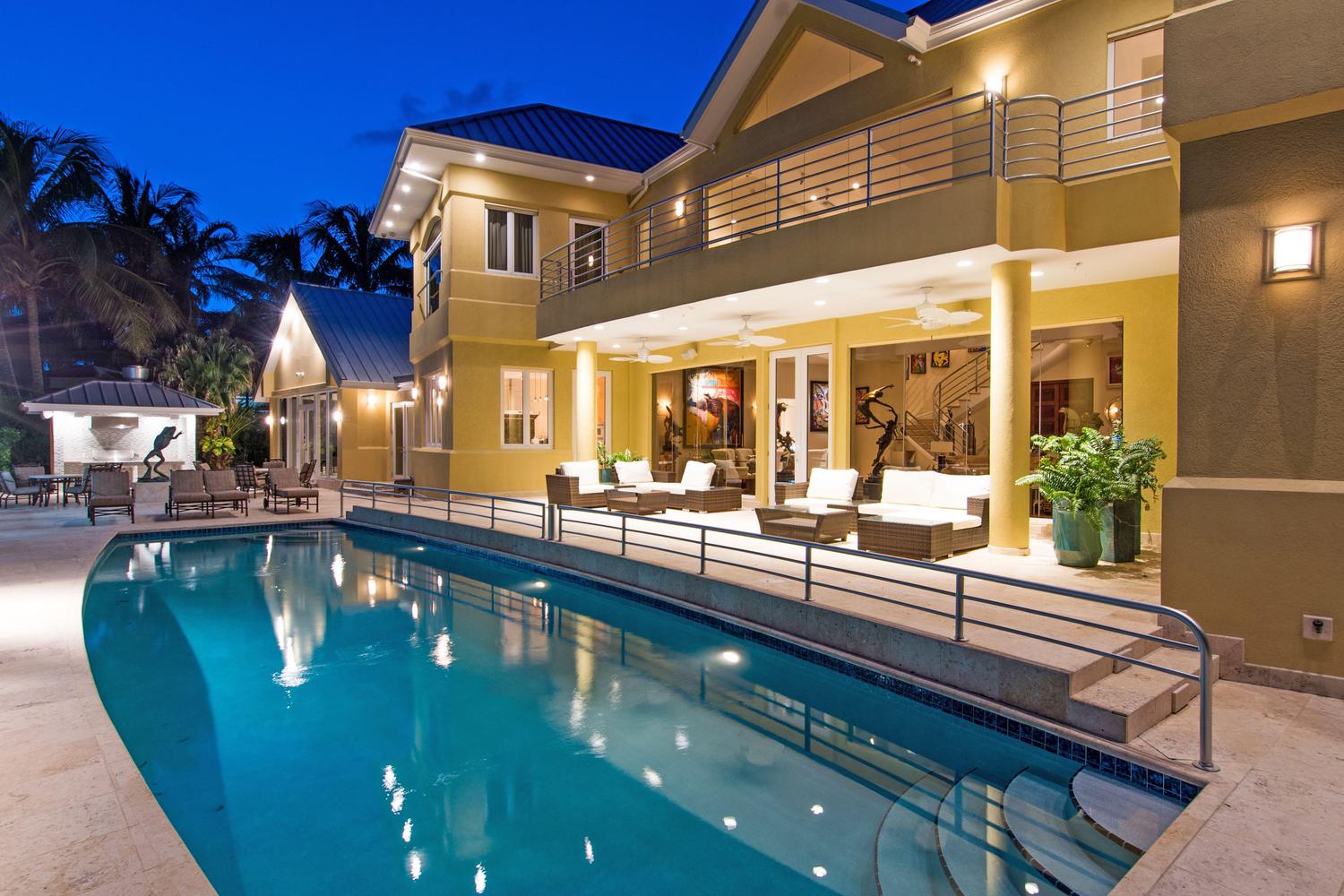 Twilight view of a lit pool and deck