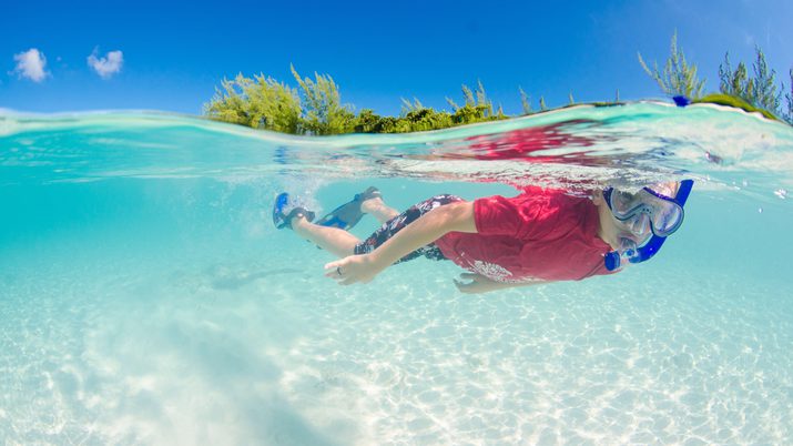 Boy snorkeling in clear water in the Cayman Islands