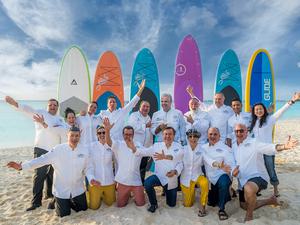 Cayman cookout chefs at the beach in front of surfboards