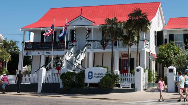 Group of people walking past the National Museum of the Cayman Islands
