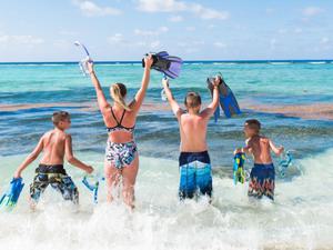 Family about to go snorkelling at the beach in Cayman