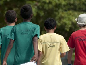 Group of young boys walking next to an athletics track