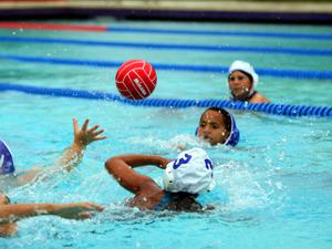 Group of young teenagers playing water polo in large swimming pool