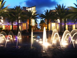 Water fountain lit up at night at Camana Bay