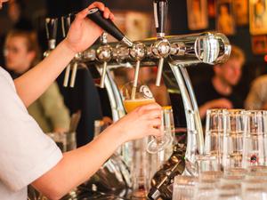 Close crop of bartender pouring a draught beer