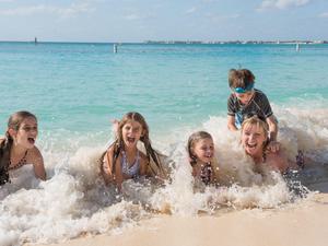 Four young kids playing in the surf