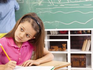 Little girl in pink collared shirt studying