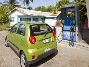 Little green car parked out from of an esso