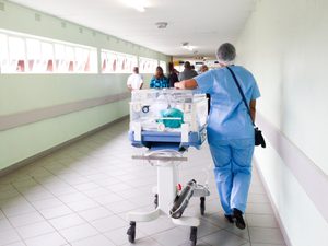 Newborn baby being walked down hospital hallway