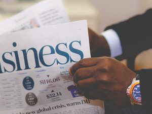 Person reading the business section of the newspaper