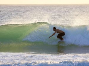 Surfer with dark hair on a wave in South Sound