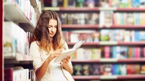 Teenager ready a book in a library