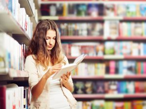 Teenager ready a book in a library