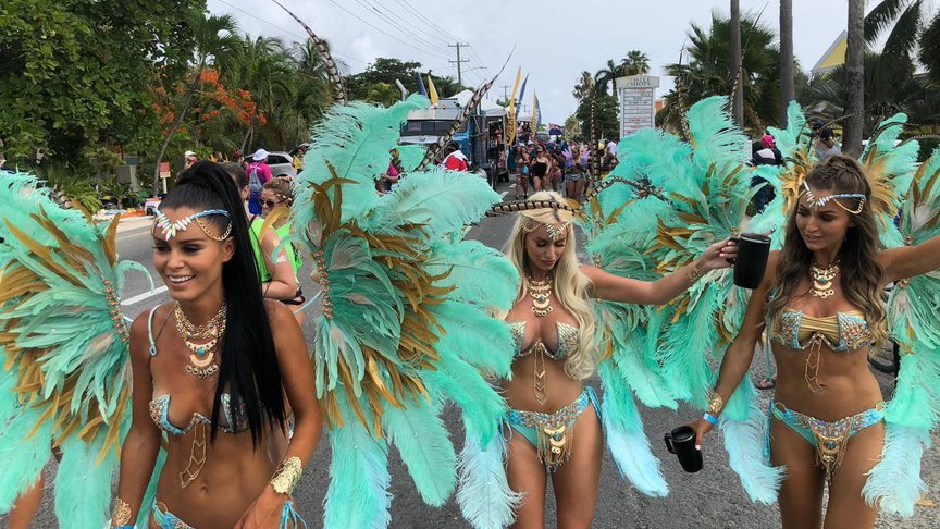 Three girls in carnival wear walking down west bay road
