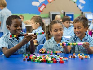 Three school age children playing with blocks