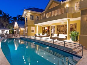 Twilight view of a lit pool and deck