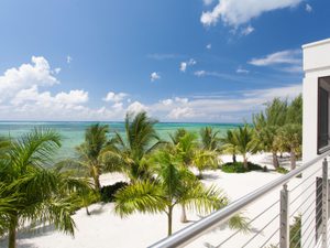 View off of a white luxury condo balcony overlooking the ocean